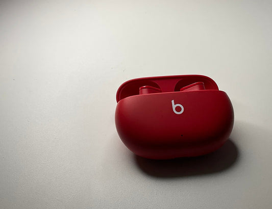 Photo of the Beats Studio Buds in red. It's a full set (left earbud, right earbud, and charging case).